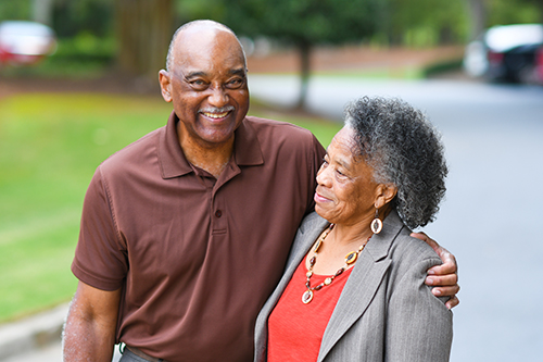 Elderly african american couple outside smiling and embracing each other
